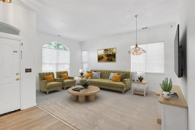 a living room with furniture kitchen view and a window