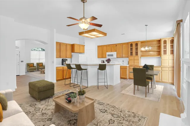 a living room with furniture kitchen view and a large window