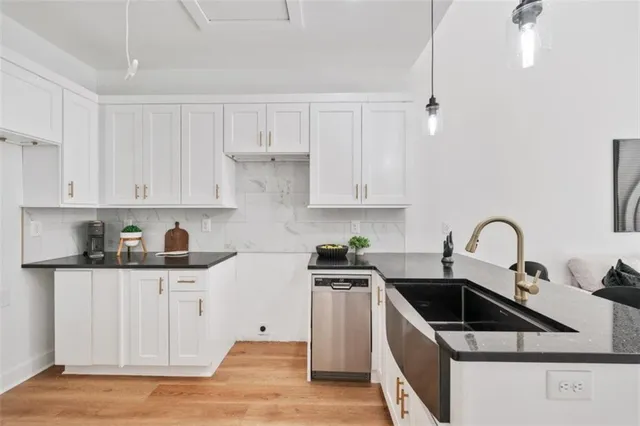 a kitchen with granite countertop a sink a stove and cabinets