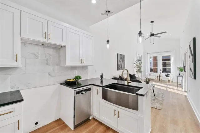 a kitchen with a sink a counter top space and living room view