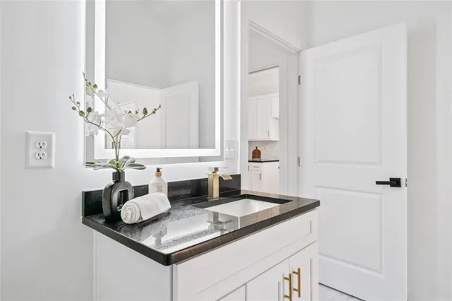 a bathroom with a granite countertop sink a toilet and a window