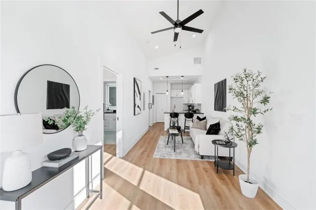 a living room with furniture a potted plant and a large window