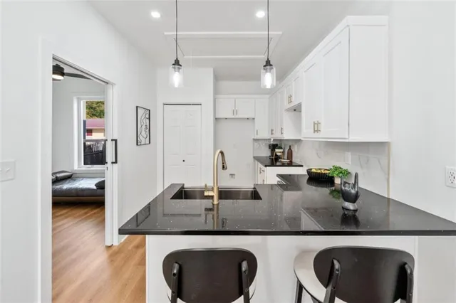 a kitchen with white cabinets a sink stove and refrigerator