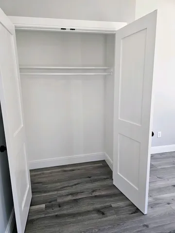 a view of walk in closet with wooden floor