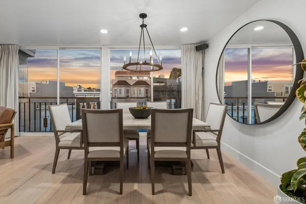 a view of a dining room with furniture a chandelier and wooden floor