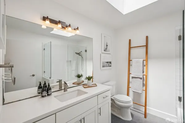 a bathroom with a sink a toilet and mirror