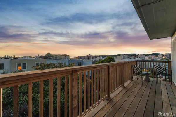 a balcony with wooden floor and fence