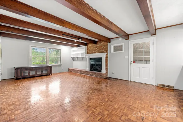 a view of an empty room with a window and fireplace