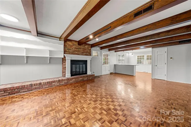 a view of empty room with wooden floor and fireplace