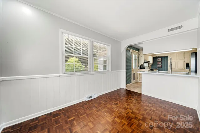 a view of a kitchen with wooden floor and a refrigerator