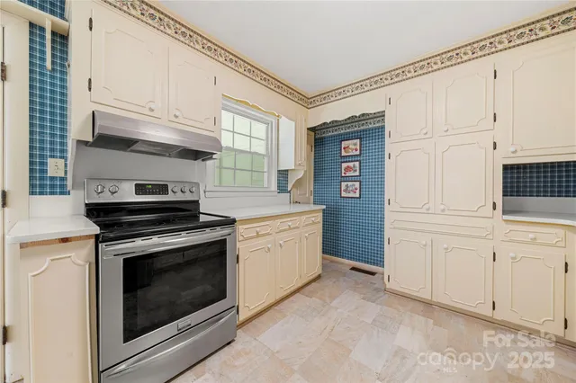 a kitchen with granite countertop white cabinets and stainless steel appliances
