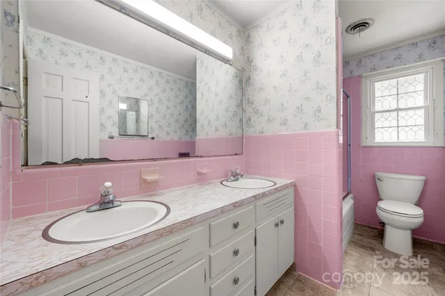 a bathroom with a granite countertop sink a toilet and a mirror