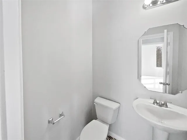 a bathroom with a toilet a sink and mirror
