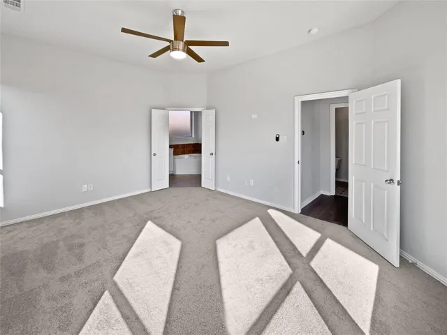 a spacious bedroom with a bed and a chandelier