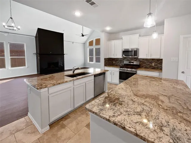 a kitchen with stainless steel appliances granite countertop a sink stove and refrigerator