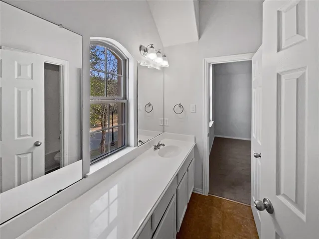 a spacious bathroom with a double vanity sink and a mirror