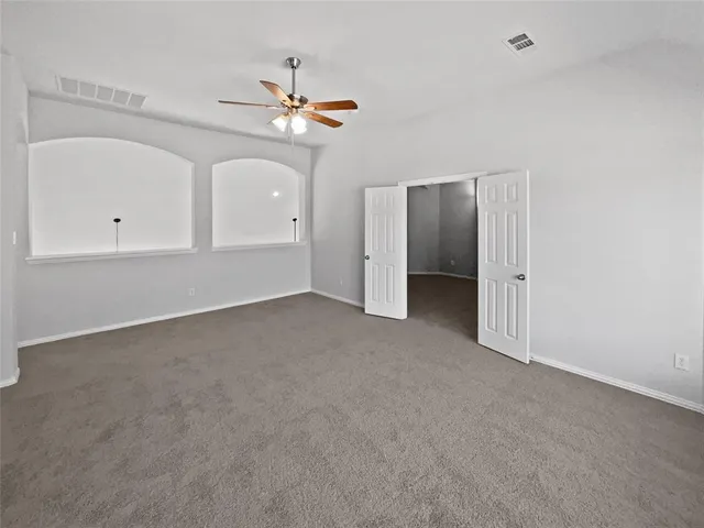an empty room with a ceiling fan and a window