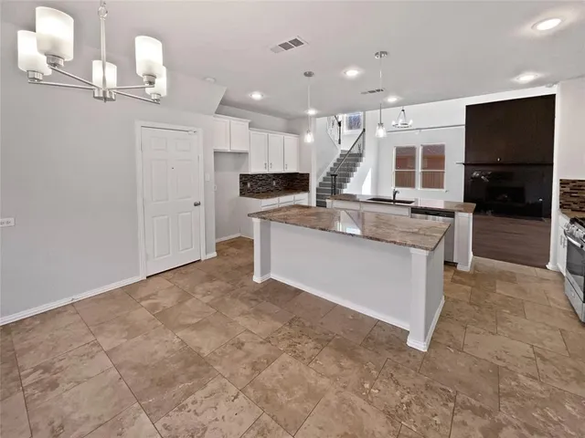 a large kitchen with a large counter top appliances and cabinets