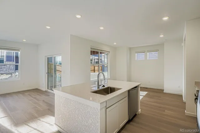 a kitchen with stainless steel appliances granite countertop a sink and a wooden floors