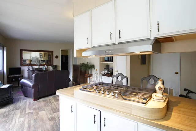 a kitchen with kitchen island granite countertop a sink cabinets and stainless steel appliances