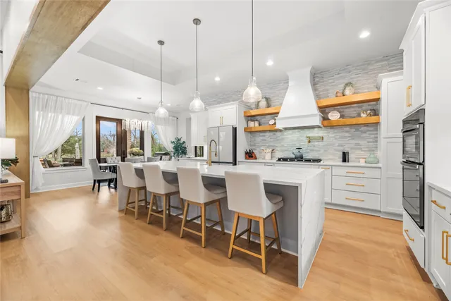 a dining table with chairs and kitchen view