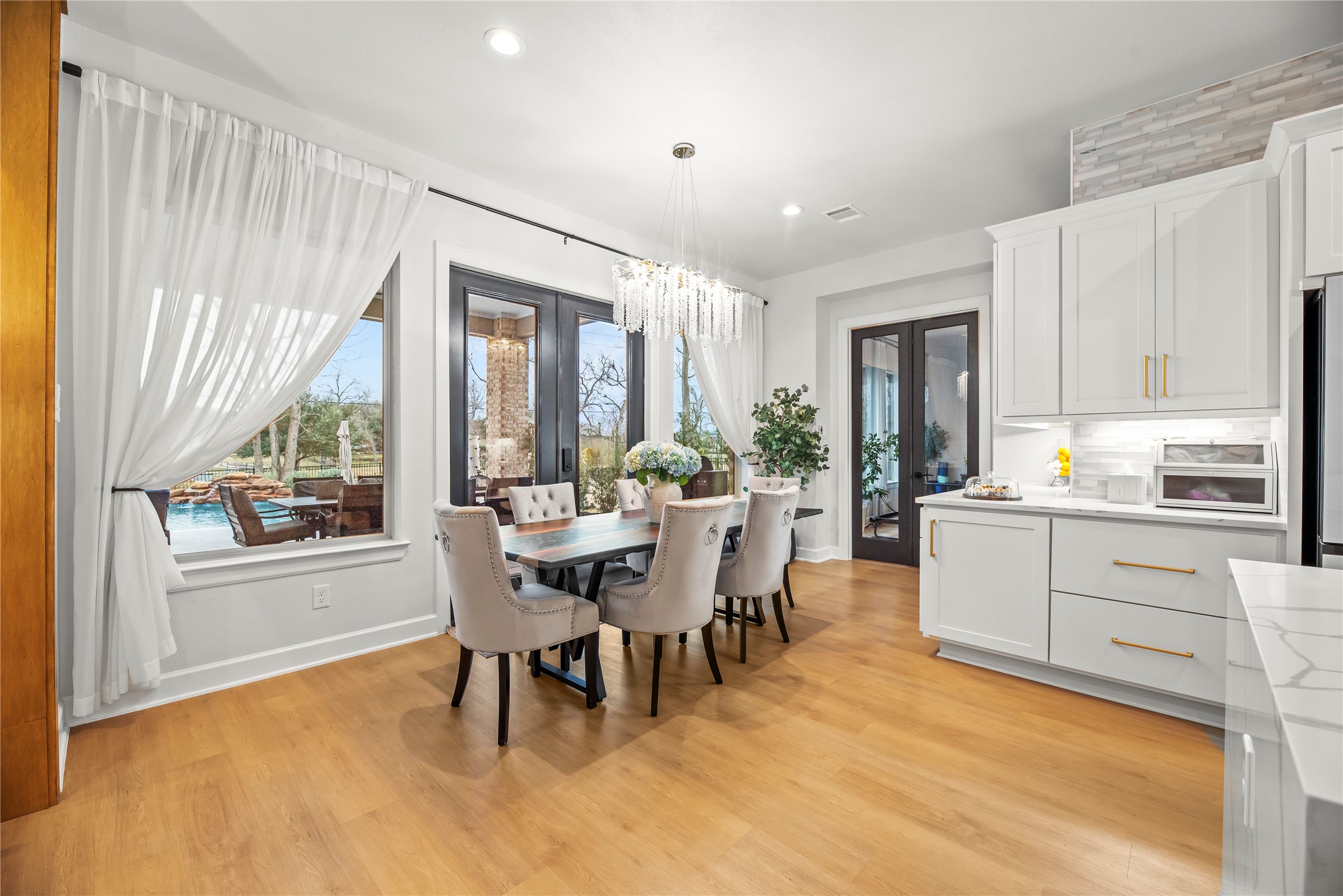 4218 Wooded Isle Way Fulshear, TX 77441 - Photo 14 of 50 a kitchen with a table chairs and a refrigerator