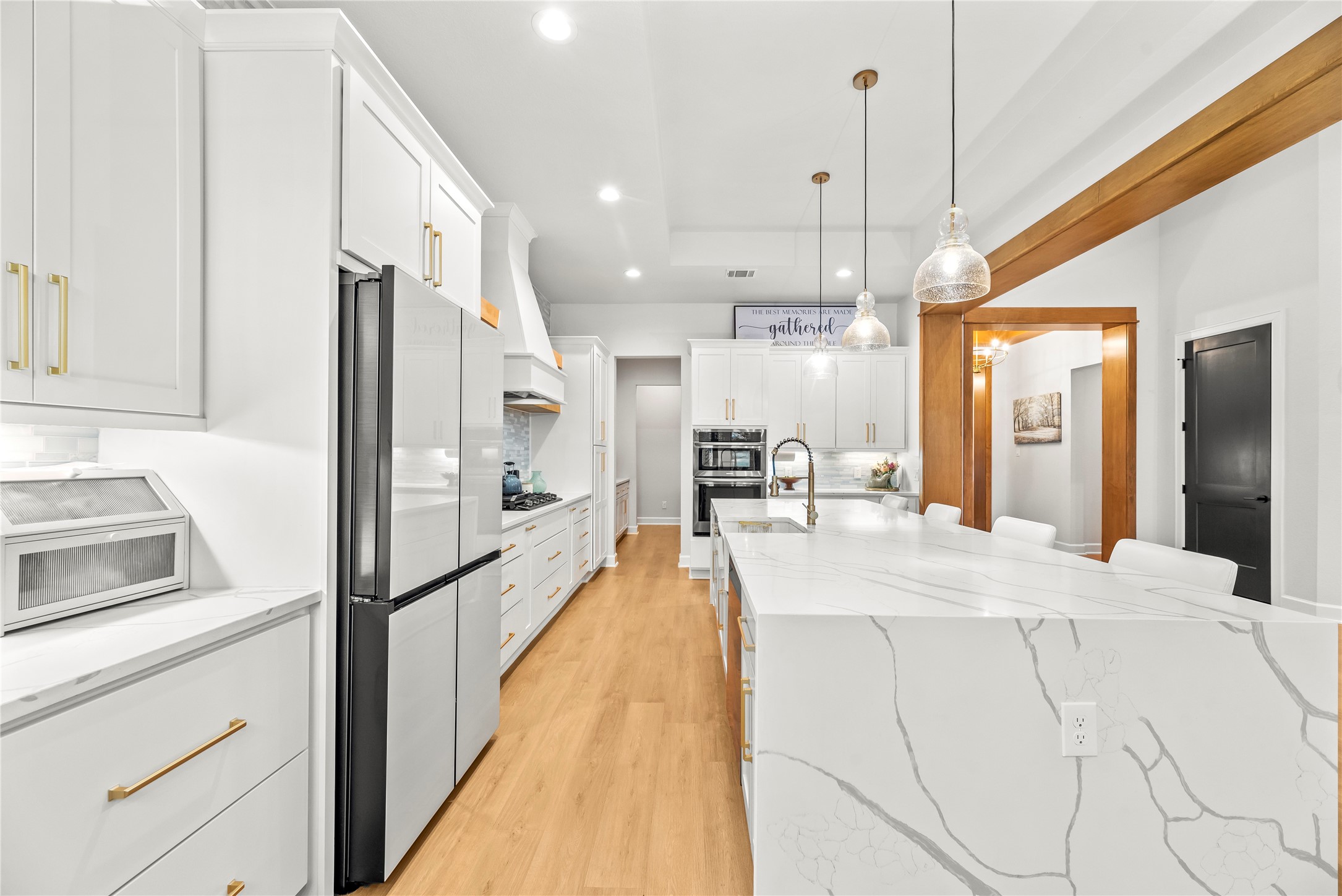 4218 Wooded Isle Way Fulshear, TX 77441 - Photo 17 of 50 a large kitchen with kitchen island a large counter top and stainless steel appliances