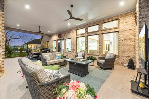 a living room with patio furniture and a chandelier