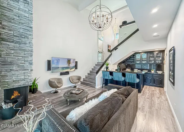 a view of a livingroom with furniture a fireplace wooden floor and a chandelier