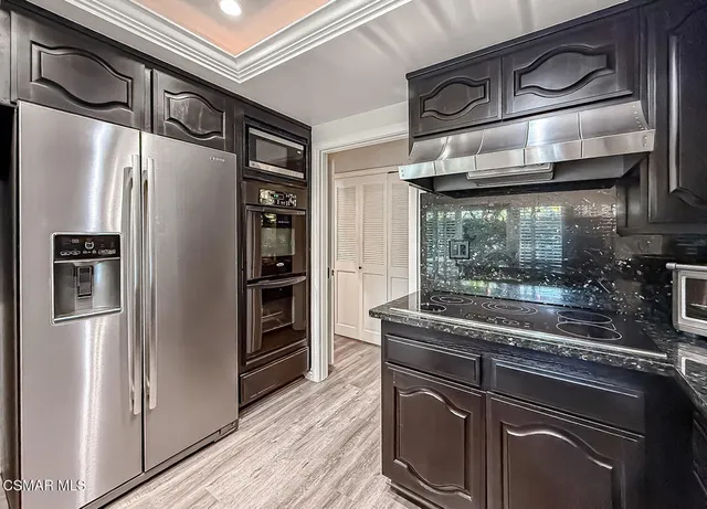 a kitchen with stainless steel appliances granite countertop a refrigerator and a stove