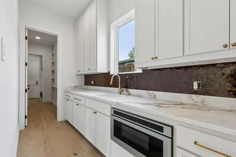 a kitchen with granite countertop white cabinets and sink