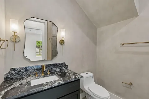 a bathroom with a toilet sink and mirror