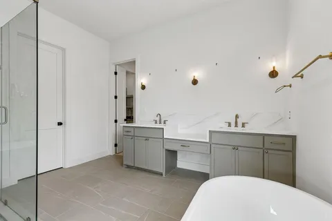 a bathroom with a sink vanity granite tub and shower