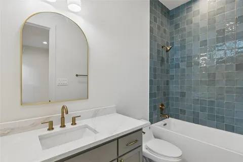 a bathroom with a sink toilet vanity and bathtub