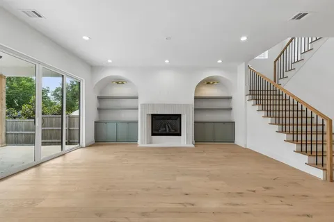 a view of an empty room with a fireplace and a window