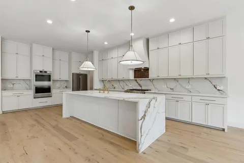 a kitchen with kitchen island granite countertop white cabinets and white appliances