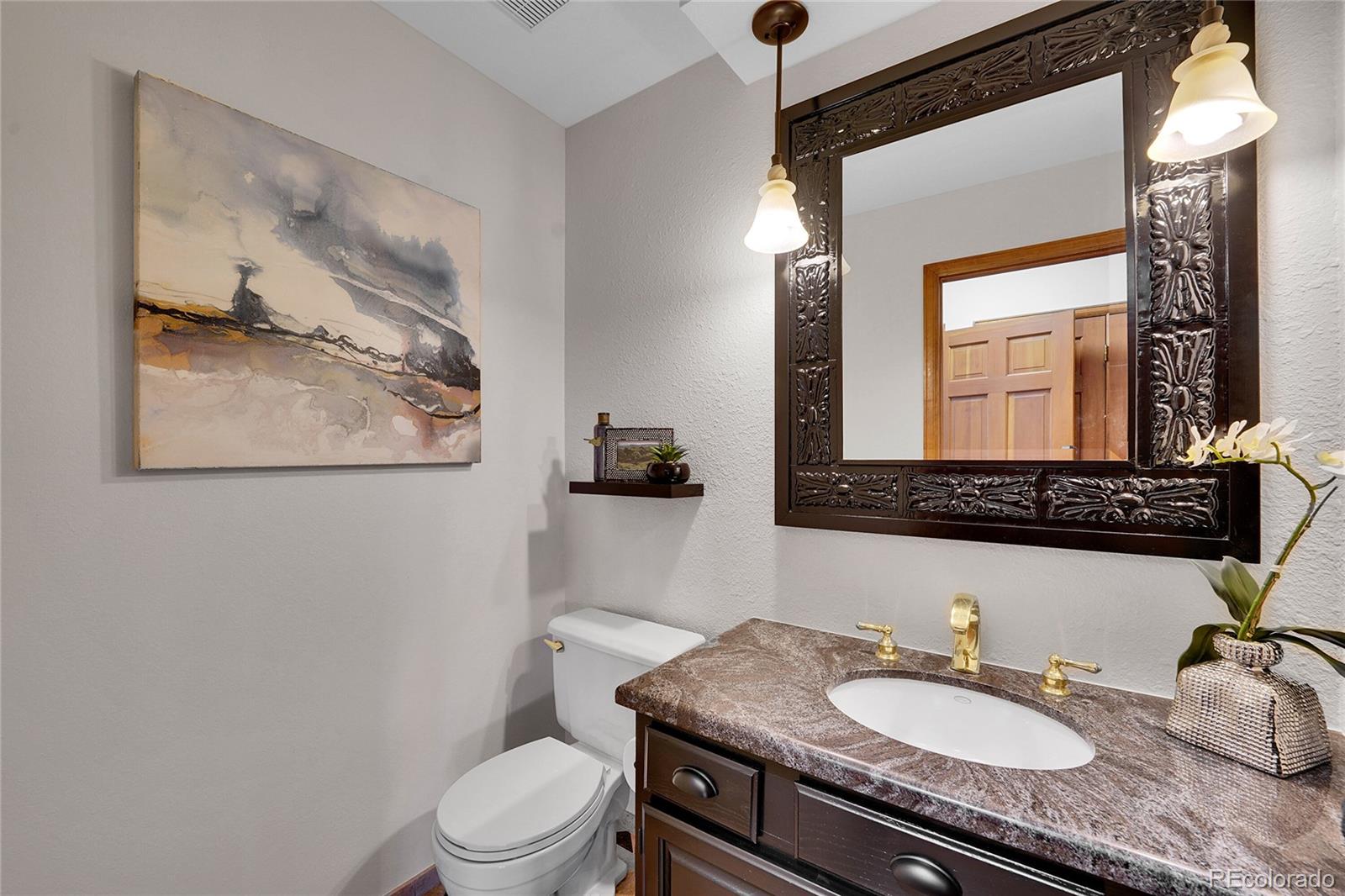 2226 Thistle Ridge Circle Highlands Ranch, CO 80126 - Photo 17 of 49 a bathroom with a granite countertop toilet a sink and a mirror