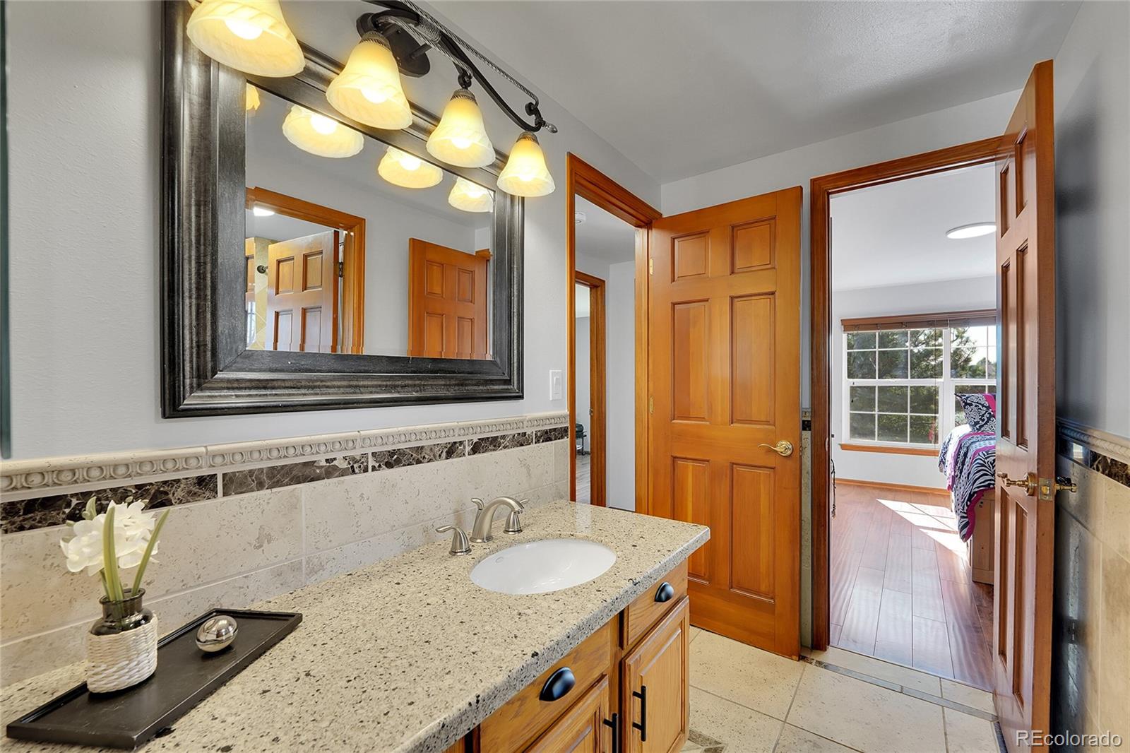 2226 Thistle Ridge Circle Highlands Ranch, CO 80126 - Photo 25 of 49 a bathroom with a granite countertop sink and a mirror