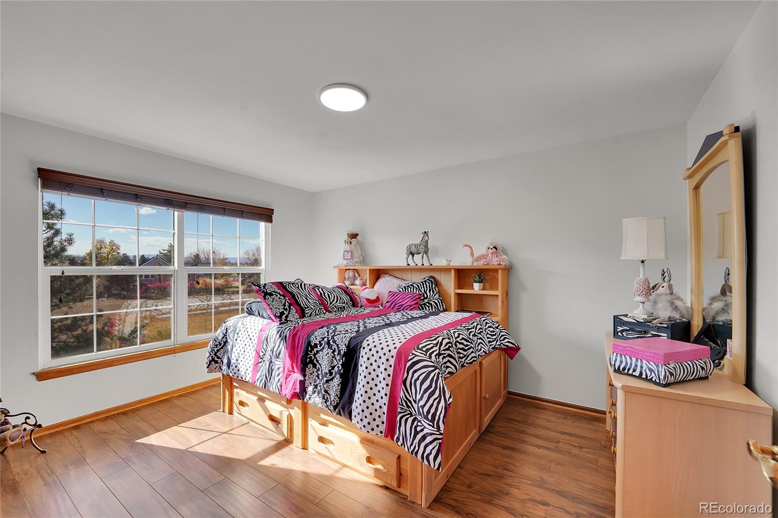 2226 Thistle Ridge Circle Highlands Ranch, CO 80126 - Photo 27 of 49 a bedroom with a bed and wooden floor