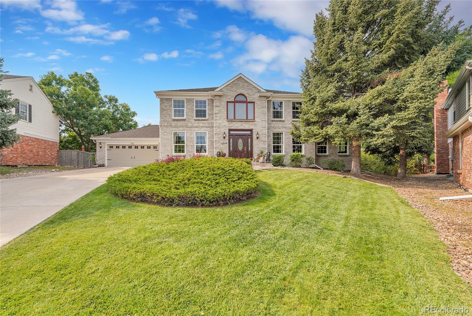 2226 Thistle Ridge Circle Highlands Ranch, CO 80126 - Photo 4 of 49 a view of a white house next to a yard with large trees