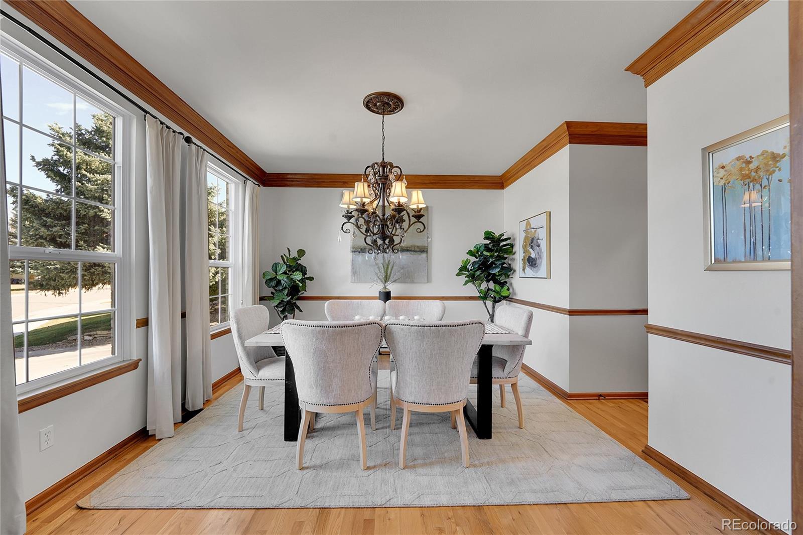 2226 Thistle Ridge Circle Highlands Ranch, CO 80126 - Photo 7 of 49 a dining room with furniture a chandelier and wooden floor