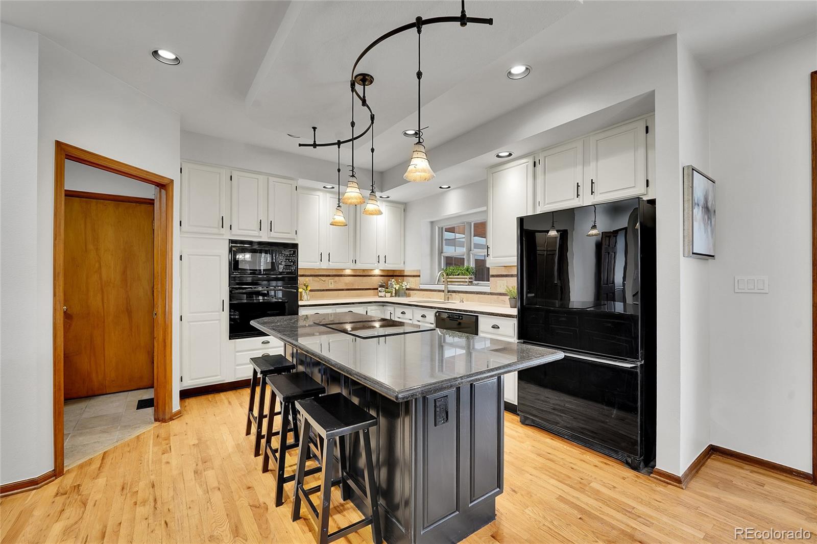 2226 Thistle Ridge Circle Highlands Ranch, CO 80126 - Photo 10 of 49 a kitchen with kitchen island a counter top space a refrigerator and a fireplace