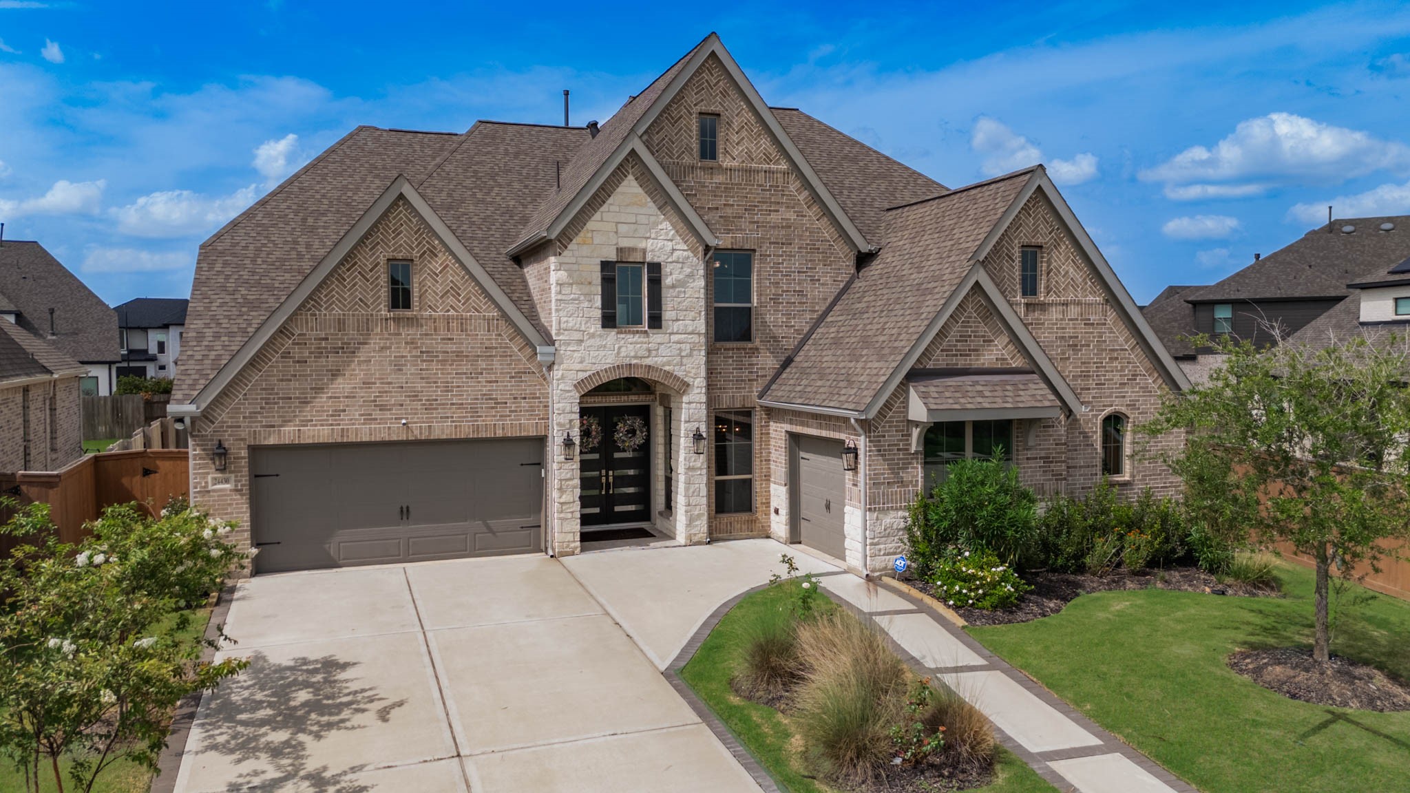 24430 Switchgrass Vly Way Katy, TX 77493 - Photo 2 of 50 This charming two-story brick home features a modern design with a spacious driveway, two-car garage, and well-maintained landscaping. The entryway is inviting with a blend of stone and brick, creating a welcoming atmosphere.