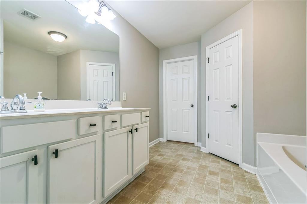 4358 Grove Field Court Northwest Suwanee, GA 30024 - Photo 13 of 17 a bathroom with a sink a vanity and a mirror