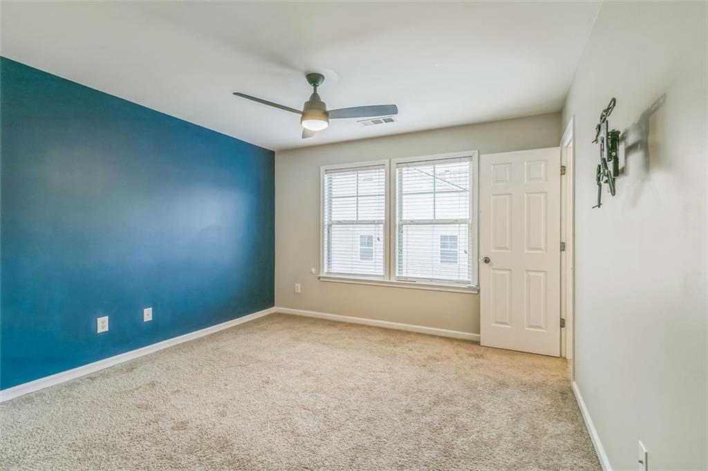 4358 Grove Field Court Northwest Suwanee, GA 30024 - Photo 17 of 17 an empty room with windows and chandelier fan