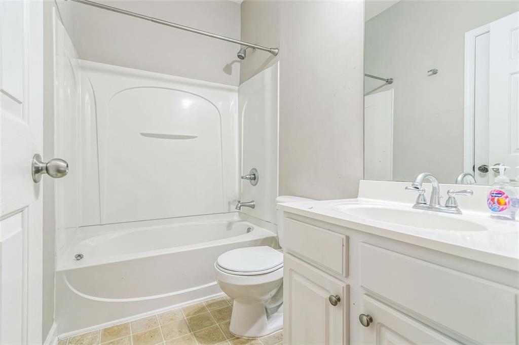 4358 Grove Field Court Northwest Suwanee, GA 30024 - Photo 5 of 17 a bathroom with a granite countertop sink toilet a mirror and shower