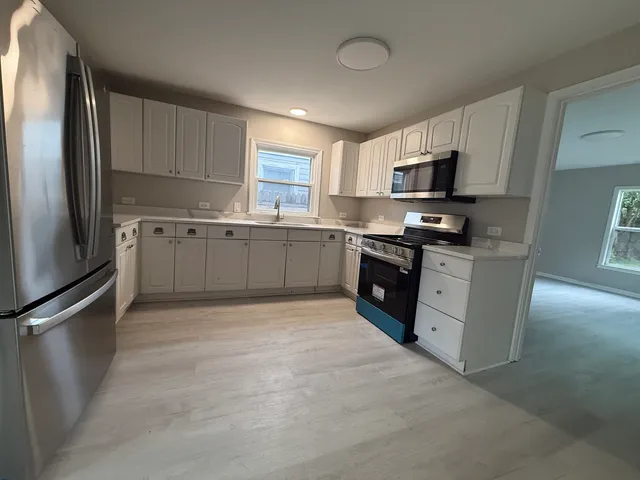 a kitchen with stainless steel appliances granite countertop a refrigerator stove and sink