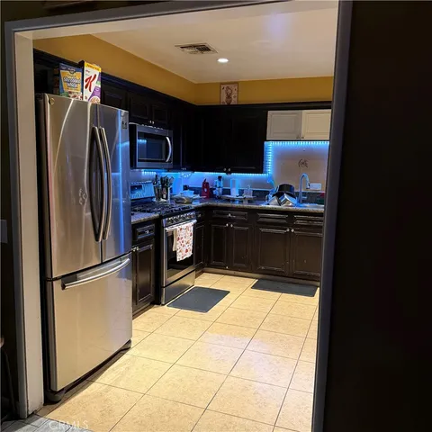 a kitchen with stainless steel appliances granite countertop a refrigerator and a stove top oven