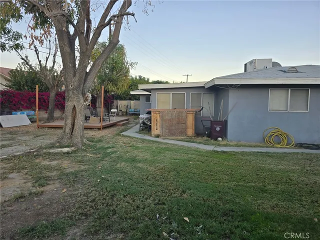 a backyard of a house with barbeque oven and table and chairs
