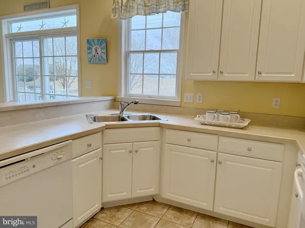 a kitchen with granite countertop white cabinets and window